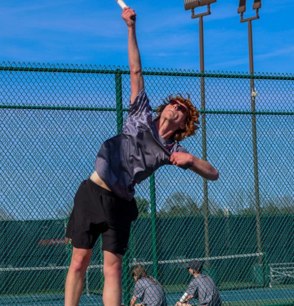 Senior Elijah goes up for a serve against Ontario